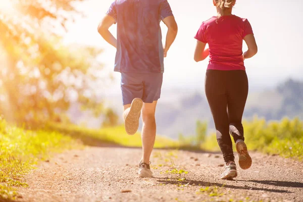 Jeune couple jogging sur la journée ensoleillée à la nature — Photo