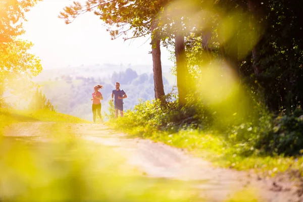 Jovem casal jogging no dia ensolarado na natureza — Fotografia de Stock