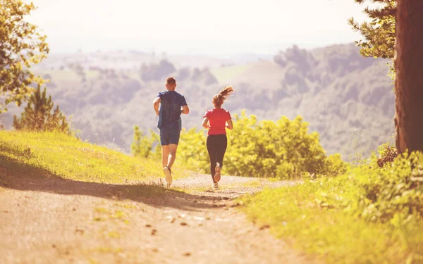 Jovem casal jogging no dia ensolarado na natureza — Fotografia de Stock