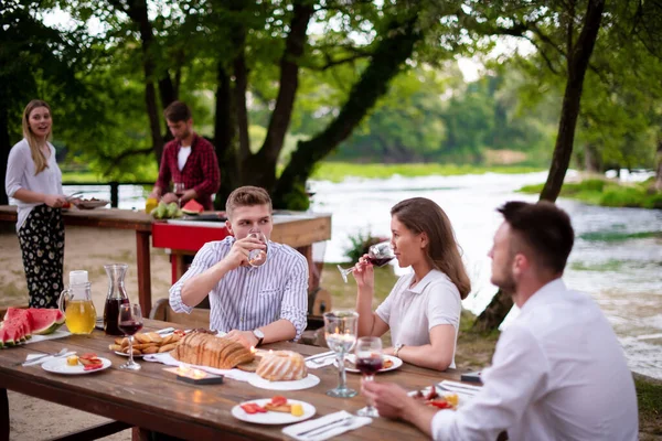 Glückliche Freunde mit Picknick Französisch Dinner Party im Freien — Stockfoto