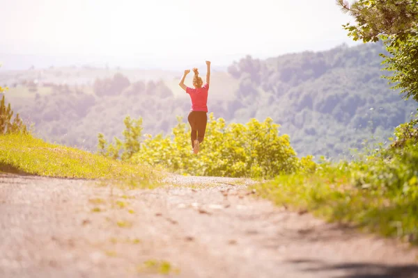 Ung kvinna jogga på solig dag i naturen — Stockfoto