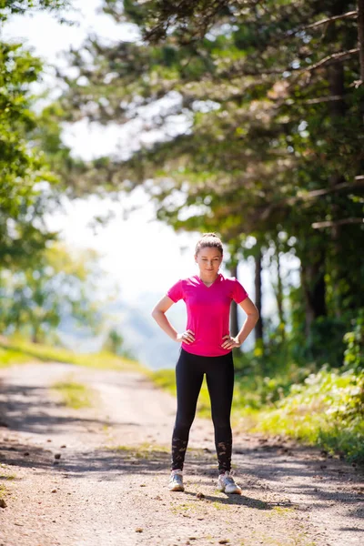 Portret van jonge vrouw joggen op zonnige dag in de natuur — Stockfoto