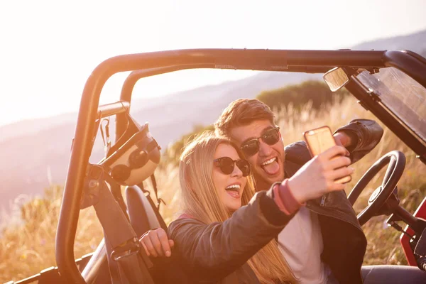 Joven pareja tomando selfie foto mientras conducción un off road bugg — Foto de Stock