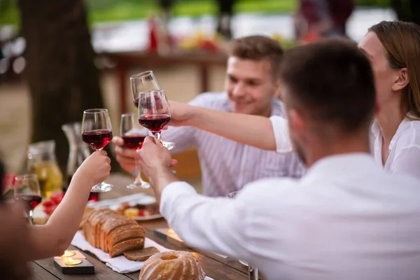 Amigos felices brindar copa de vino tinto durante la cena francesa —  Fotos de Stock