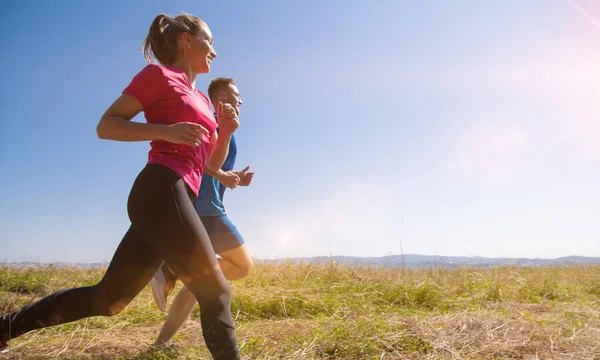 Giovane coppia che fa jogging in giornata di sole in montagna estiva — Foto Stock