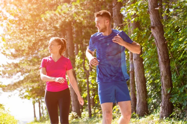 Giovane coppia che fa jogging in giornata di sole nella natura — Foto Stock