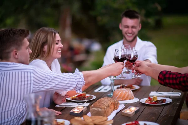 Boldog barátok pirítóssal vörösbor pohár alatt francia vacsora party — Stock Fotó