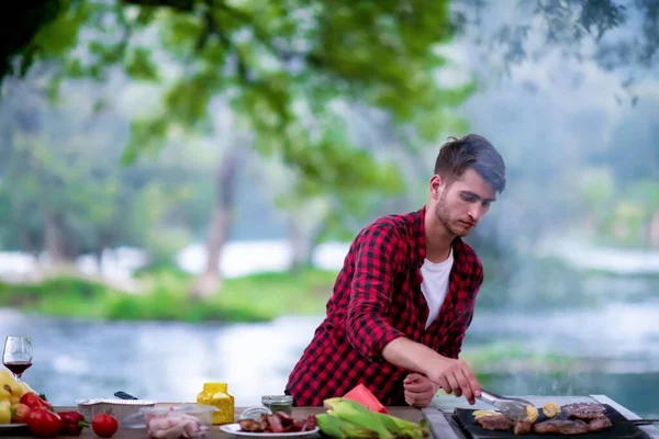 Hombre cocina sabrosa comida en la parrilla barbacoa — Foto de Stock