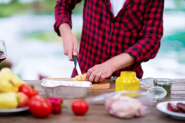 Homem cortando legumes para salada ou churrasqueira — Fotografia de Stock