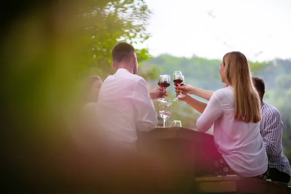 Glückliche Freunde stoßen auf Rotweinglas bei französischem Abendessen an — Stockfoto