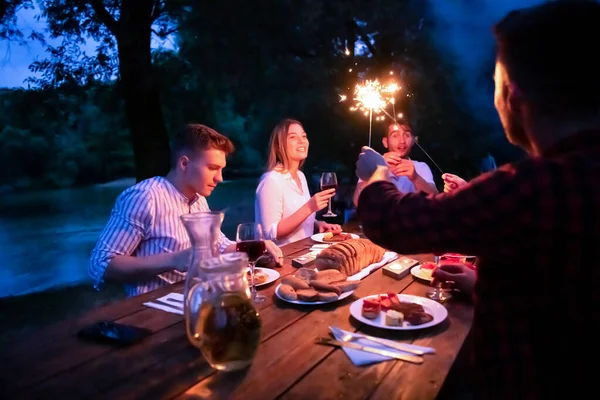 Счастливые друзья с французским ужином на открытом воздухе — стоковое фото