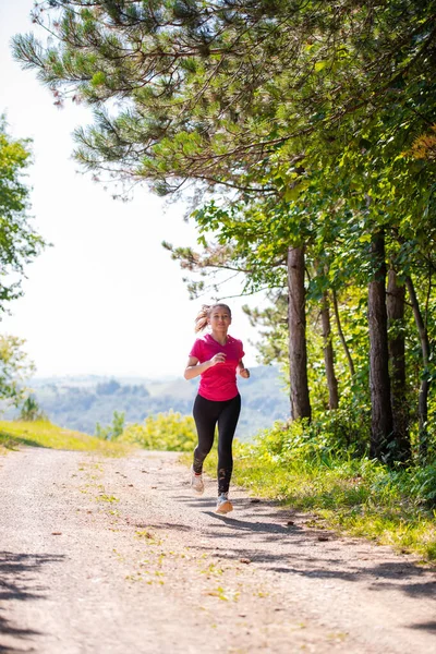 Giovane donna che fa jogging in una giornata di sole nella natura — Foto Stock