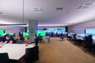 Güvenlik Veri Merkezi operatörleri bir CCTV izleme odasında birden fazla monitöre bakıyor. Sistem Kontrol Odası 'nda çalışan şüpheli aktiviteler için birden fazla ekran görüntülüyor.