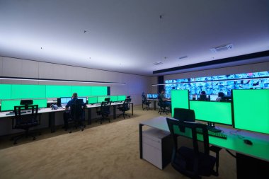 Güvenlik Veri Merkezi operatörleri bir CCTV izleme odasında birden fazla monitöre bakıyor. Sistem Kontrol Odası 'nda çalışan şüpheli aktiviteler için birden fazla ekran görüntülüyor.