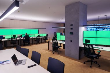 Güvenlik Veri Merkezi operatörleri bir CCTV izleme odasında birden fazla monitöre bakıyor. Sistem Kontrol Odası 'nda çalışan şüpheli aktiviteler için birden fazla ekran görüntülüyor.