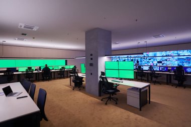 Güvenlik Veri Merkezi operatörleri bir CCTV izleme odasında birden fazla monitöre bakıyor. Sistem Kontrol Odası 'nda çalışan şüpheli aktiviteler için birden fazla ekran görüntülüyor.