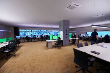 Güvenlik Veri Merkezi operatörleri bir CCTV izleme odasında birden fazla monitöre bakıyor. Sistem Kontrol Odası 'nda çalışan şüpheli aktiviteler için birden fazla ekran görüntülüyor.