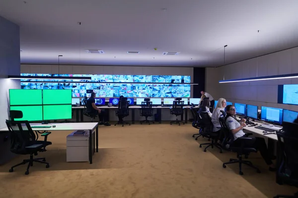 Güvenlik Veri Merkezi operatörleri bir CCTV izleme odasında birden fazla monitöre bakıyor. Sistem Kontrol Odası 'nda çalışan şüpheli aktiviteler için birden fazla ekran görüntülüyor.