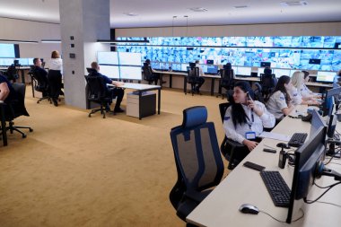 Güvenlik Veri Merkezi operatörleri bir CCTV izleme odasında birden fazla monitöre bakıyor. Sistem Kontrol Odası 'nda çalışan şüpheli aktiviteler için birden fazla ekran görüntülüyor.