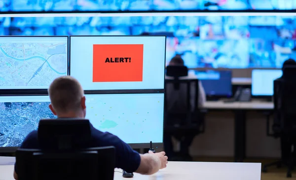 Male security operator working in a data system control room offices Technical Operator Working at  workstation with multiple displays, security guard working on multiple monitors  Male computer operator monitoring from a security center Alarm signal