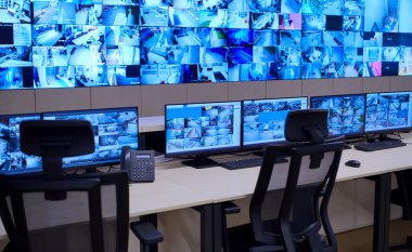 Büyük, modern güvenlik kontrol odasının içi boş, birden fazla ekranı olan çalışma istasyonu, güvenlik veri merkezindeki izleme odası boş ofis, masa ve ana CCTV veri merkezindeki sandalyeler.