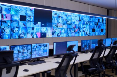 Büyük, modern güvenlik kontrol odasının içi boş, birden fazla ekranı olan çalışma istasyonu, güvenlik veri merkezindeki izleme odası boş ofis, masa ve ana CCTV veri merkezindeki sandalyeler.