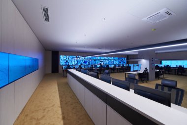 Büyük, modern güvenlik kontrol odasının içi boş, birden fazla ekranı olan çalışma istasyonu, güvenlik veri merkezindeki izleme odası boş ofis, masa ve ana CCTV veri merkezindeki sandalyeler.