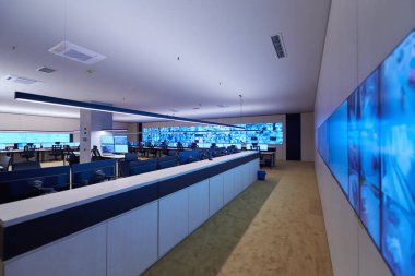 Büyük, modern güvenlik kontrol odasının içi boş, birden fazla ekranı olan çalışma istasyonu, güvenlik veri merkezindeki izleme odası boş ofis, masa ve ana CCTV veri merkezindeki sandalyeler.