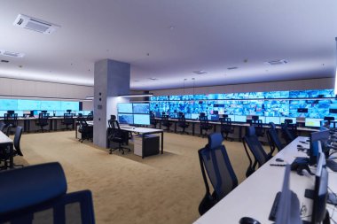 Büyük, modern güvenlik kontrol odasının içi boş, birden fazla ekranı olan çalışma istasyonu, güvenlik veri merkezindeki izleme odası boş ofis, masa ve ana CCTV veri merkezindeki sandalyeler.