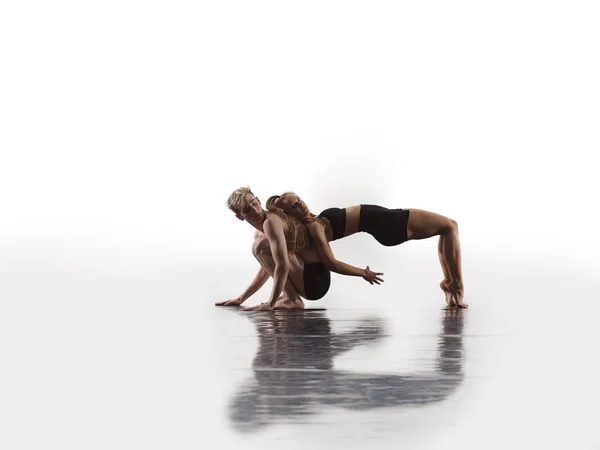 ブラックタイツの若いアスレチックダンスパートナーのカップルがアクロバティックな要素を作る現代的なスタイルのバレエを上演白い背景の前で芸術パフォーマンスのスポーティバレエダンサーのカップル — ストック写真