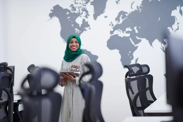 站在现代开放式计划启动办公室时 带绿色头巾手持平板电脑的穆斯林非洲女软件开发人员的肖像 — 图库照片