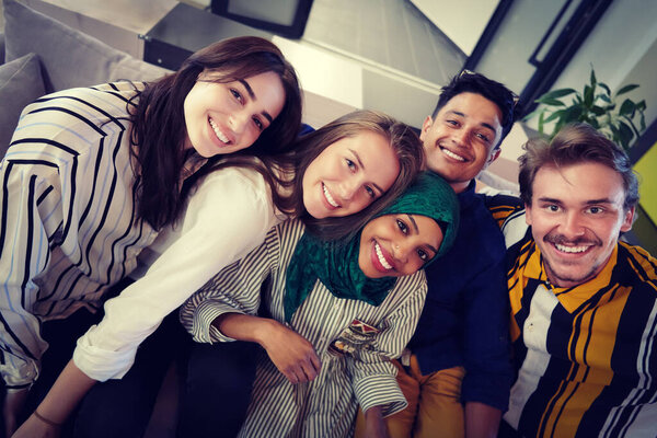 group of casual multiethnic business people during break from the work taking selfie picture while enjoying free time in relaxation area at modern open plan startup office