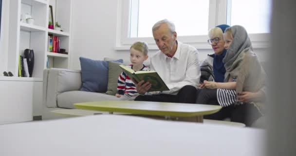 Muslimische Familie Generationen Großeltern lesen Koran mit Enkeln zu Hause — Stockvideo