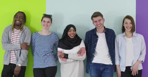 Grupo multicultural de amigos usando teléfonos celulares: estudiantes de pie en fila y escribiendo en los teléfonos inteligentes sobre la pared de color — Vídeo de stock