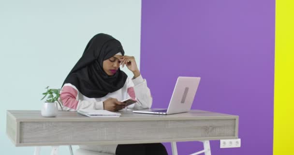 若いイスラム教徒の女性がコンピュータで働いている — ストック動画
