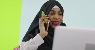 Bilgisayarda çalışan genç Müslüman kadın. 