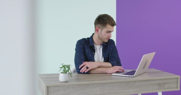 在办公桌前的笔记本电脑上工作的年轻男性 — 图库视频影像