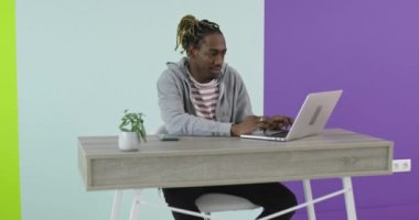 İş yerinin yakınında laptopla iş birliği yapan gülümseyen bir adam ve kadın.