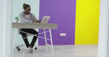 İş yerinin yakınında laptopla iş birliği yapan gülümseyen bir adam ve kadın.