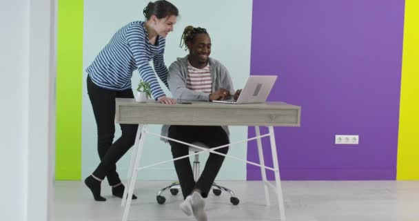 Positiv lächelnder Mann und Frau in der Nähe des Arbeitsplatzes mit Laptop im Büro — Stockvideo