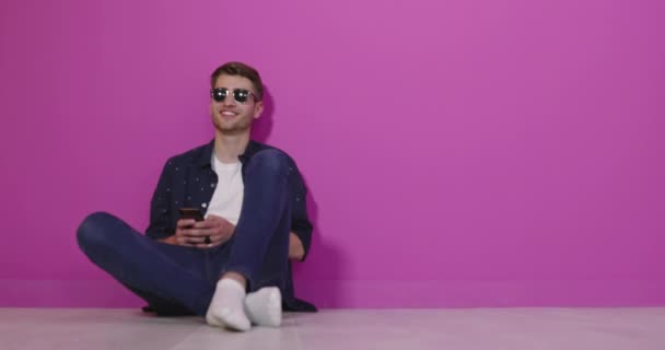 Jovem Homem Bonito Com Telefone Estúdio Colorido Fundo — Vídeo de Stock