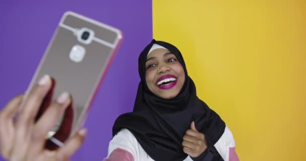 明るい背景にスマートフォンを使用して伝統的な服のイスラム教徒の女性 — ストック動画