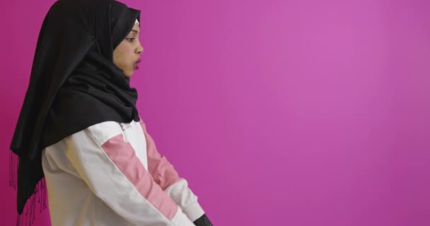 イスラム教徒の女性で伝統的な服は明るい背景で動作します — ストック動画