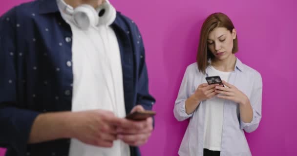 Счастливая женщина или девушка-подросток в наушниках слушает музыку со смартфона, который выбирает ее парень — стоковое видео