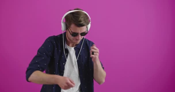 Νεαρός Όμορφος Άντρας Χαρούμενος Φορώντας Ακουστικά Στο Στούντιο Πολύχρωμο Φόντο — Αρχείο Βίντεο
