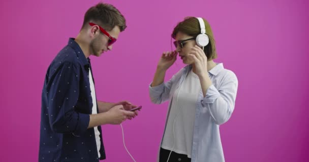 Femme heureuse ou adolescente dans un casque écoutant de la musique depuis un smartphone que son petit ami choisit — Video