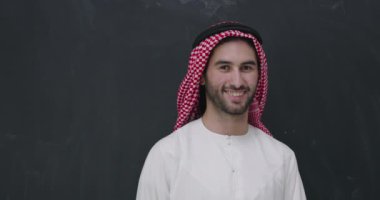Geleneksel giysiler içinde Müslüman bir adam iftar yemeğinden önce cam zeminde dua ediyor.