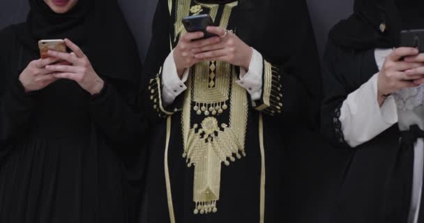 年轻的现代穆斯林商人女人用智能手机在黑色黑板前面穿着头巾的衣服 — 图库视频影像