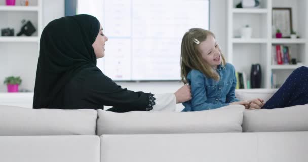 在斋月期间，传统的穆斯林家庭父母带着孩子在沙发上一起诵读《古兰经》和祈祷 — 图库视频影像