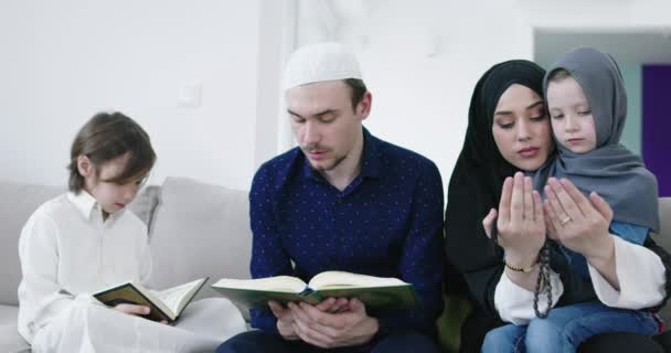 Muslimische Familie liest Koran und betet gemeinsam auf dem Sofa — Stockvideo